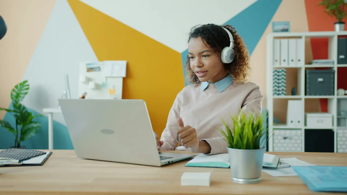 Une femme portant un casque devant un ordinateur portable